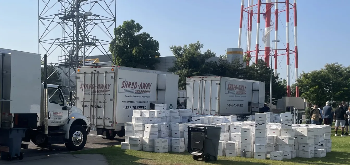 Hundreds of file boxes stacked beside Shred-Away trucks.